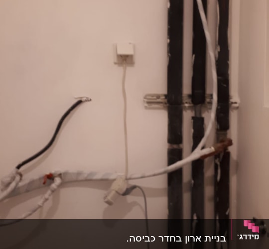 צינורות חשמל וקיר עם מטאטא קטן